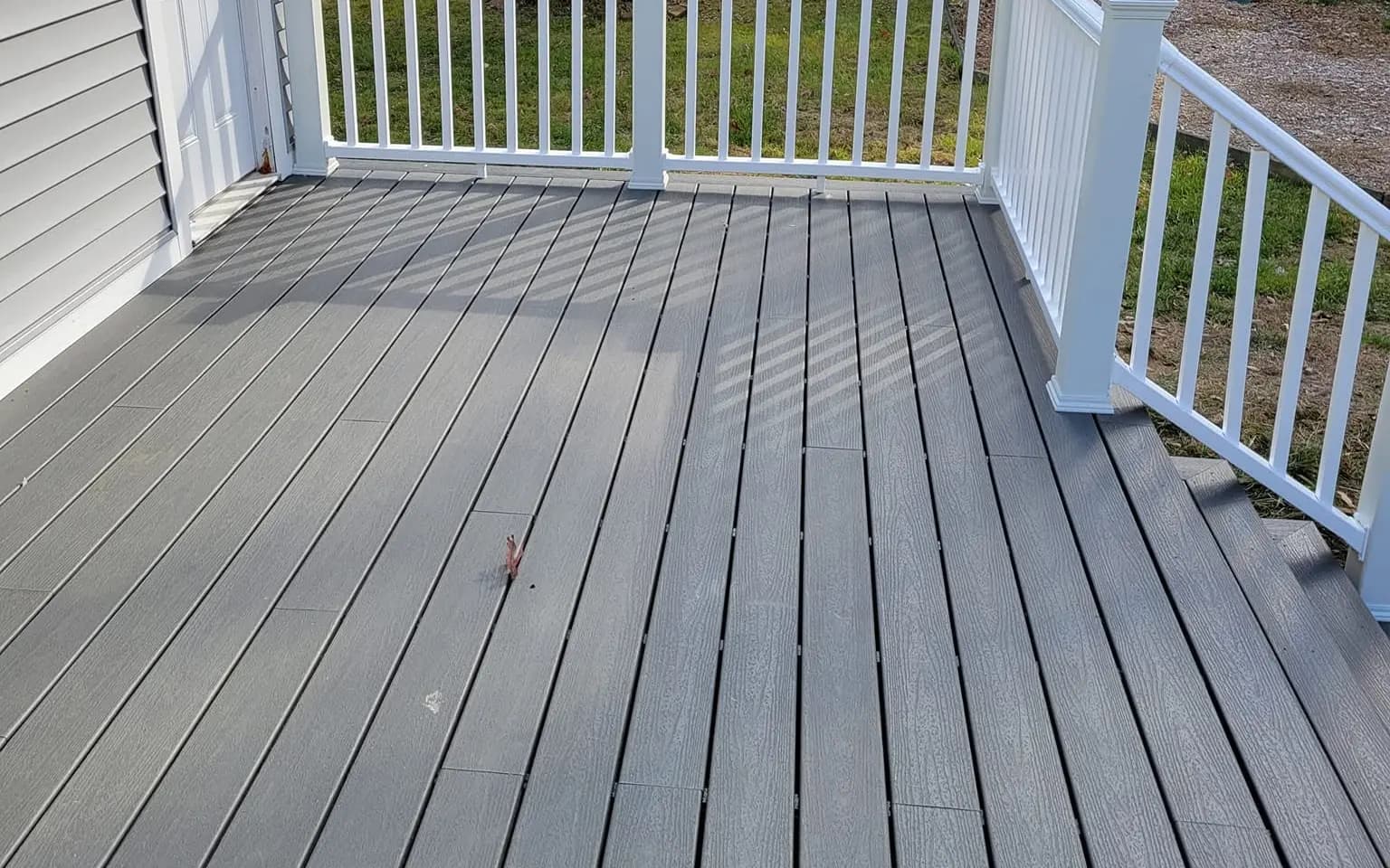 New pressure-treated wood deck and stairs on the back of a multi-family home in Central Massachusetts