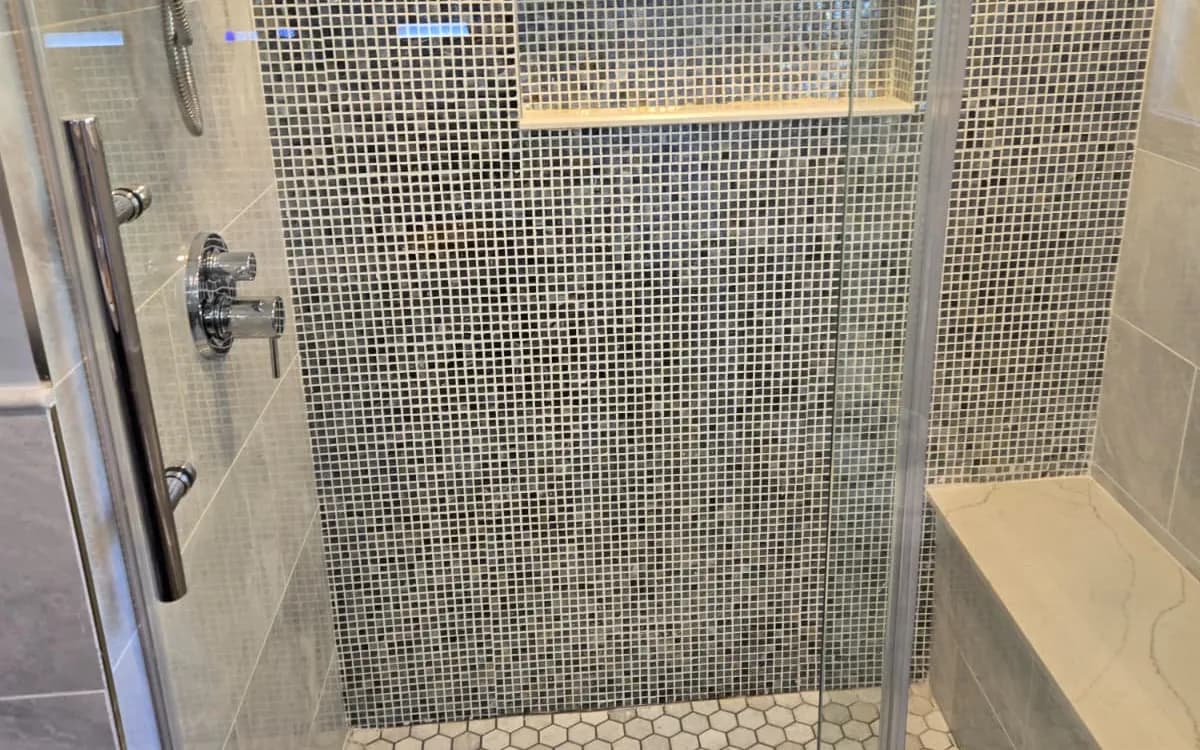 Renovated bathroom with tiled shower and new vanity in a Massachusetts home