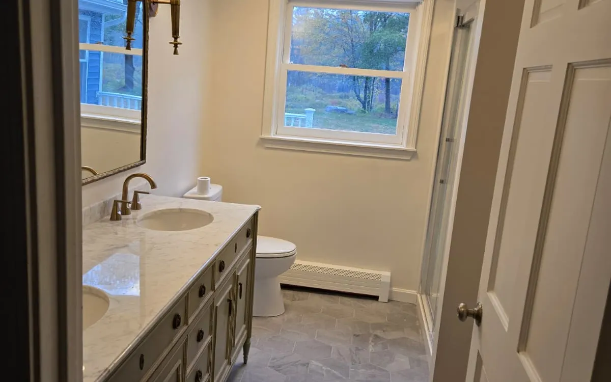 Bathroom with double vanity, arched mirrors and sconce lighting
