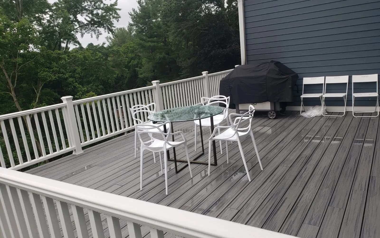 Large elevated composite deck with white railing overlooking the backyard
