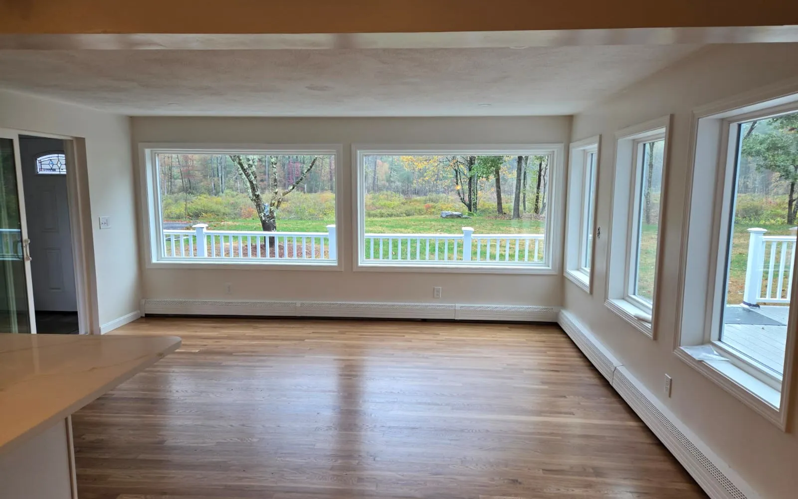 Renovated open living room with hardwood floors and large new windows