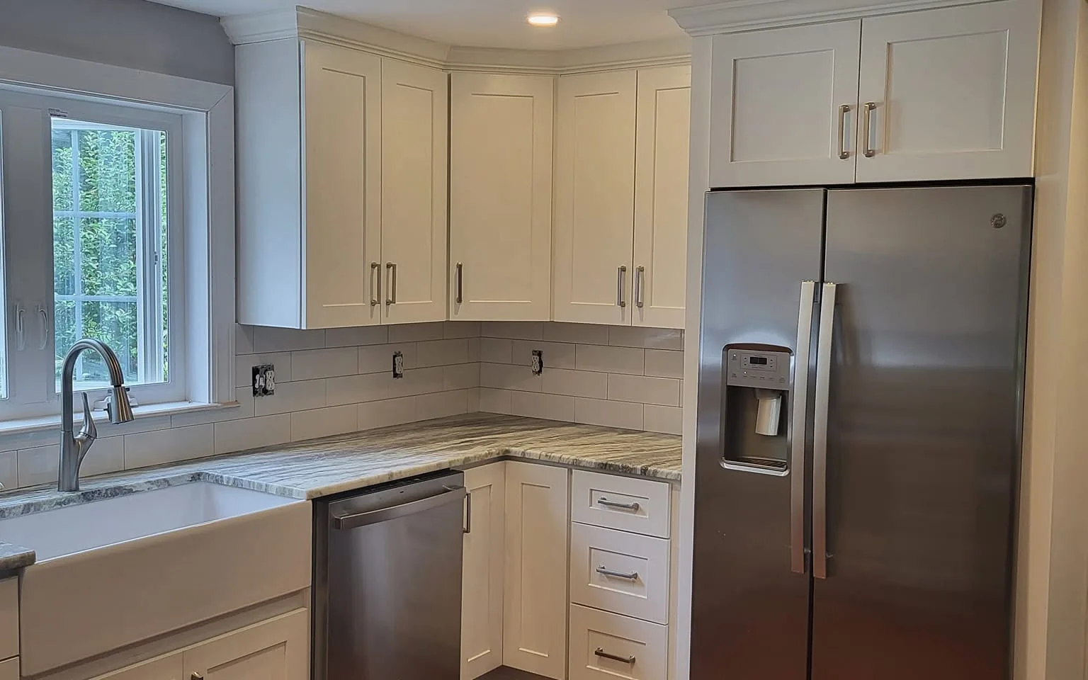 Cream shaker kitchen with hardwood floor and stainless refrigerator