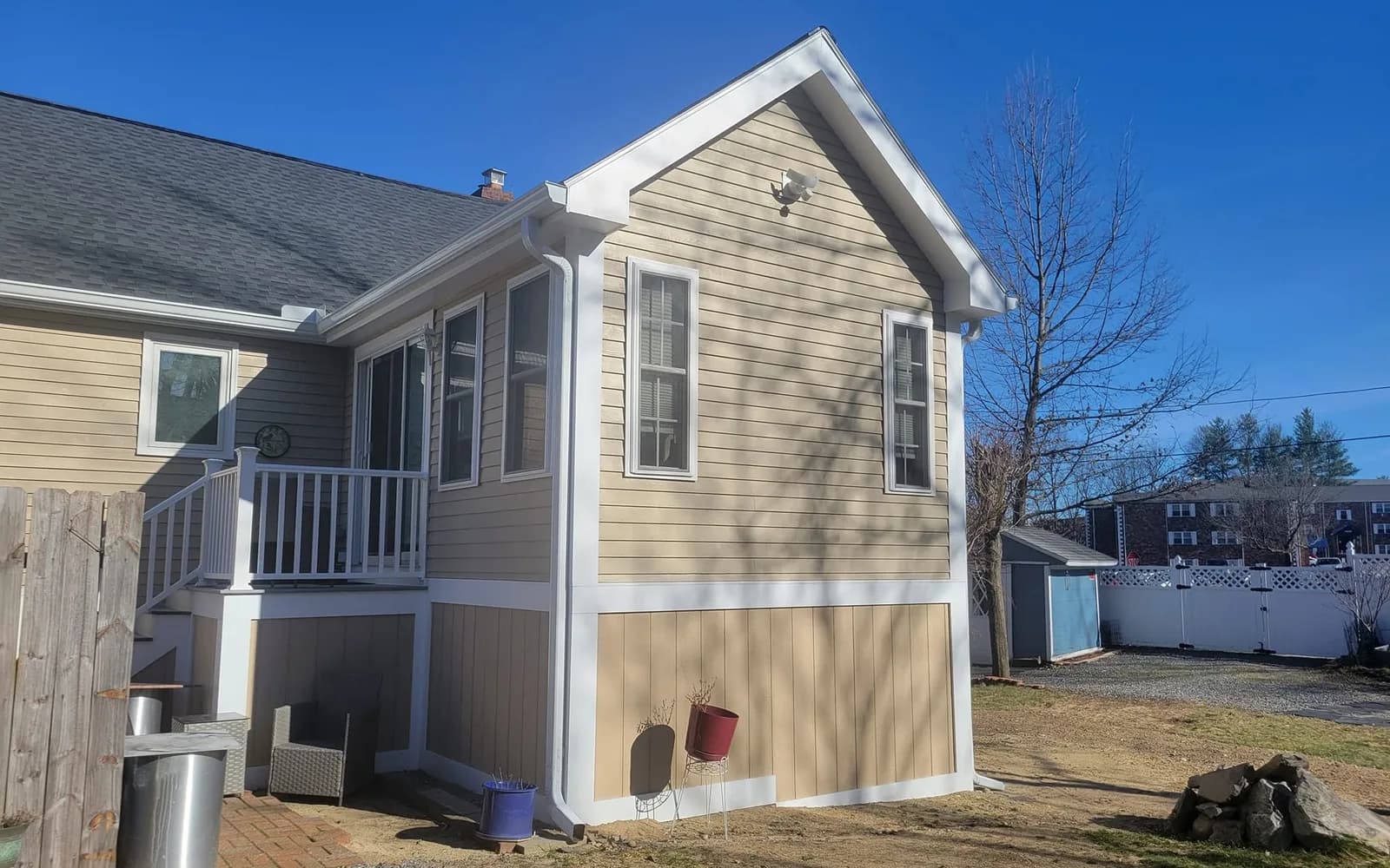 Single-story home addition with tan siding and white trim