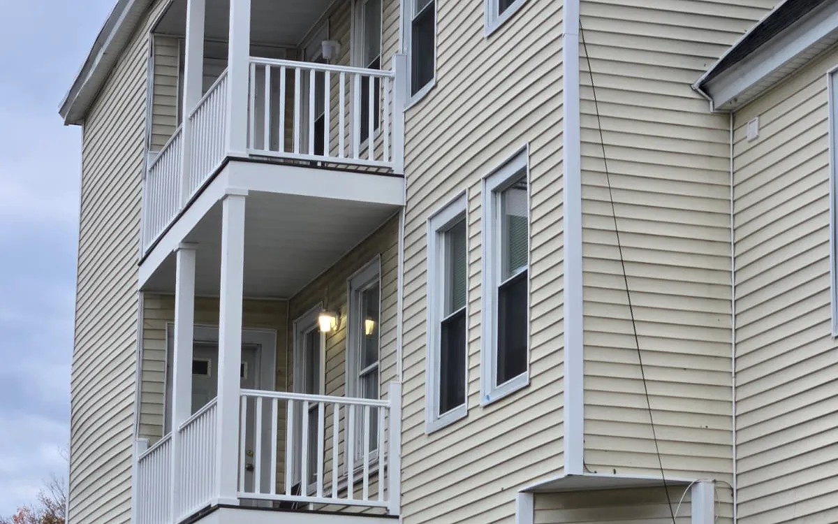 Rebuilt stacked porches with white railings on a Massachusetts triple-decker