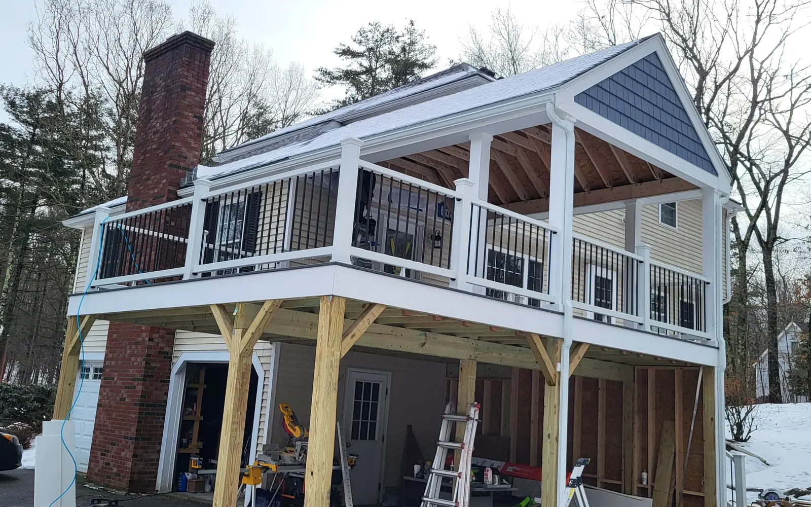 Two-story deck addition with a covered upper level, white railings and stairs built by Delane Construction
